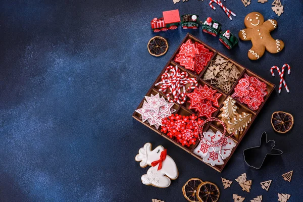 Christmas toys in white and red in a wooden sectional box against a dark concrete background. Home decorations for Christmas holiday