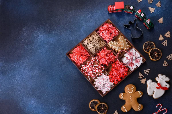 Christmas toys in white and red in a wooden sectional box against a dark concrete background. Home decorations for Christmas holiday