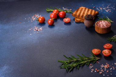 Delicious roasted ham with slices on a wooden cutting board with spices and herbs. Making a hearty breakfast