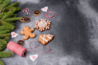 Gingerbread, Christmas tree decorations, dried citrus fruits on a gray concrete background to prepare a festive Christmas table