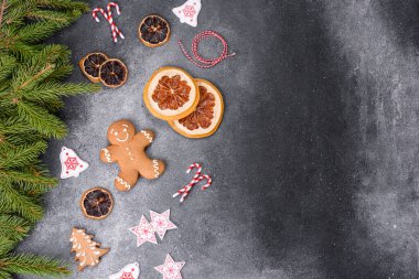 Gingerbread, Christmas tree decorations, dried citrus fruits on a gray concrete background to prepare a festive Christmas table