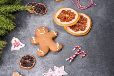 Gingerbread, Christmas tree decorations, dried citrus fruits on a gray concrete background to prepare a festive Christmas table