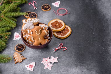 Gingerbread, Christmas tree decorations, dried citrus fruits on a gray concrete background to prepare a festive Christmas table