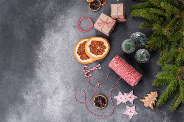 Gingerbread, Christmas tree decorations, dried citrus fruits on a gray concrete background to prepare a festive Christmas table