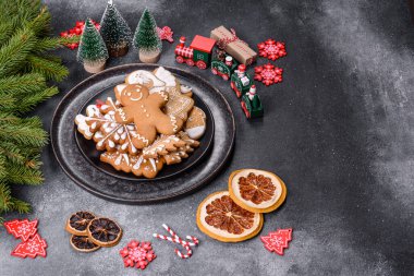 Gingerbread, Christmas tree decorations, dried citrus fruits on a gray concrete background to prepare a festive Christmas table