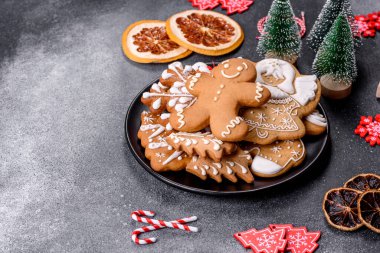 Gingerbread, Christmas tree decorations, dried citrus fruits on a gray concrete background to prepare a festive Christmas table