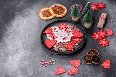 Gingerbread, Christmas tree decorations, dried citrus fruits on a gray concrete background to prepare a festive Christmas table