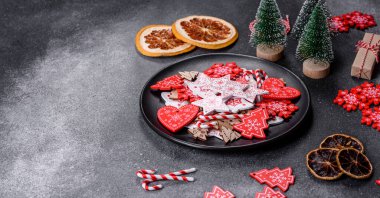 Gingerbread, Christmas tree decorations, dried citrus fruits on a gray concrete background to prepare a festive Christmas table
