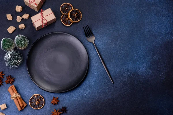A piece of fresh delicious cake with nuts and chocolate on a black plate against a dark blue background. Desserts and sweets to the dinner table