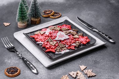 Christmas decorations and gingerbreads on a dark concrete table. Preparing and decorating the house for holiday