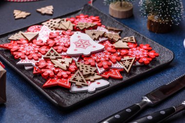 Christmas decorations and gingerbreads on a dark concrete table. Preparing and decorating the house for holiday
