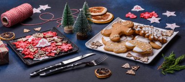 Christmas decorations and gingerbreads on a dark concrete table. Preparing and decorating the house for holiday