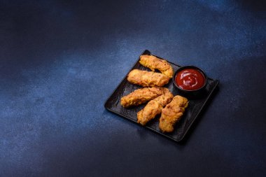 Chicken nuggets with tomato sauce on a concrete background. Copy space