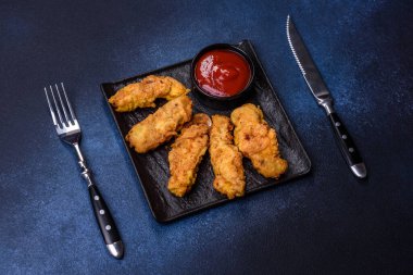 Chicken nuggets with tomato sauce on a concrete background. Copy space