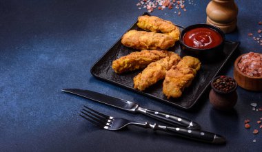 Chicken nuggets with tomato sauce on a concrete background. Copy space