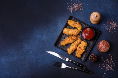 Chicken nuggets with tomato sauce on a concrete background. Copy space