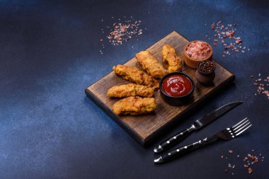 Chicken nuggets with tomato sauce on a concrete background. Copy space