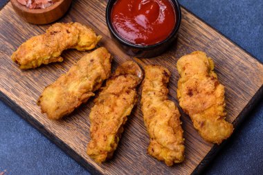 Chicken nuggets with tomato sauce on a concrete background. Copy space