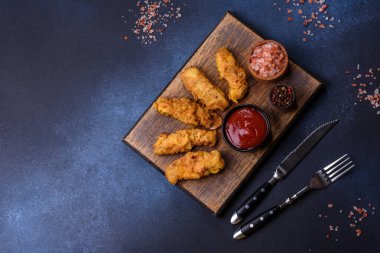 Chicken nuggets with tomato sauce on a concrete background. Copy space