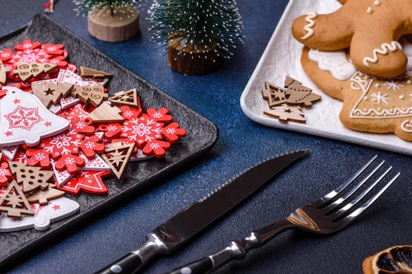Christmas decorations and gingerbreads on a dark concrete table. Preparing and decorating the house for holiday