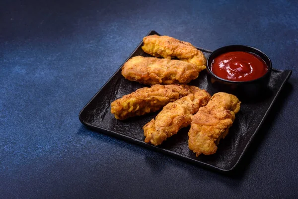 Chicken nuggets with tomato sauce on a concrete background. Copy space