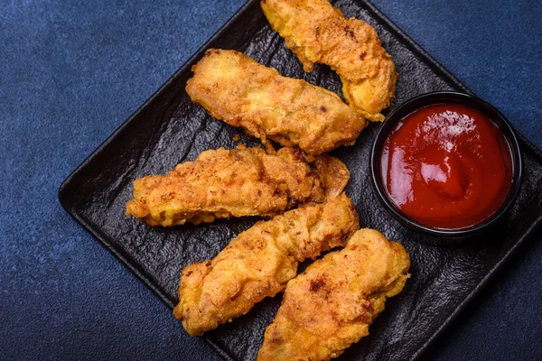 Chicken nuggets with tomato sauce on a concrete background. Copy space