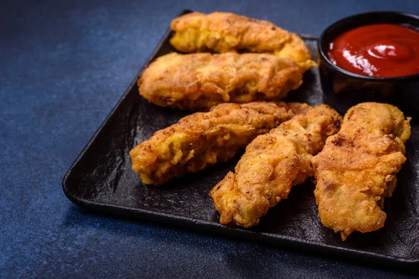 Chicken nuggets with tomato sauce on a concrete background. Copy space