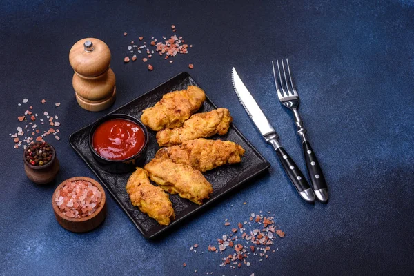 Chicken nuggets with tomato sauce on a concrete background. Copy space