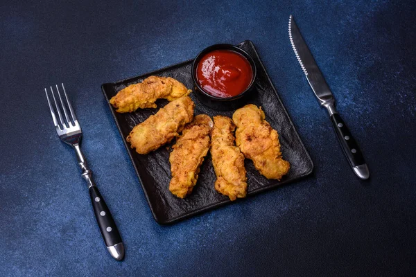 Chicken nuggets with tomato sauce on a concrete background. Copy space