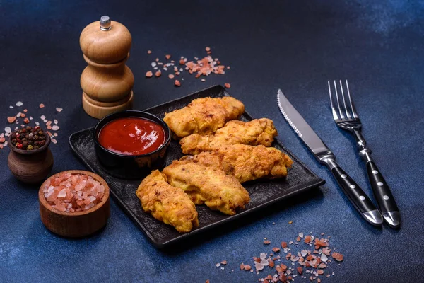 Chicken nuggets with tomato sauce on a concrete background. Copy space
