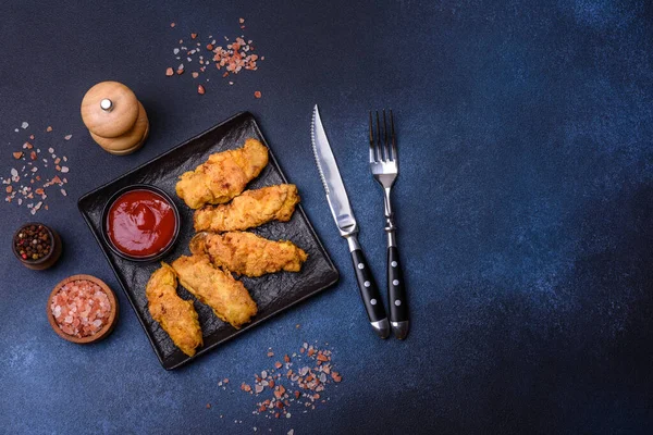 Chicken nuggets with tomato sauce on a concrete background. Copy space