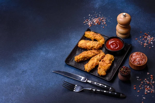 Chicken nuggets with tomato sauce on a concrete background. Copy space