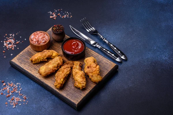 Chicken nuggets with tomato sauce on a concrete background. Copy space