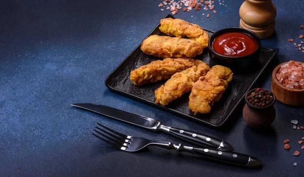 Chicken nuggets with tomato sauce on a concrete background. Copy space