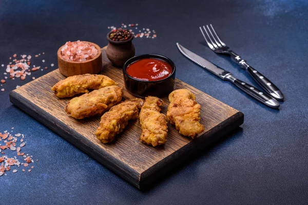Chicken nuggets with tomato sauce on a concrete background. Copy space