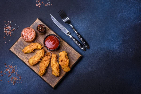 Chicken nuggets with tomato sauce on a concrete background. Copy space