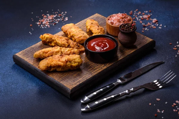 Chicken nuggets with tomato sauce on a concrete background. Copy space