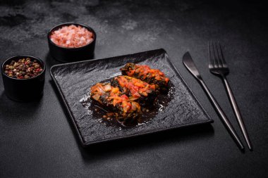 Dolma, stuffed grape leaves with rice and meat on a dark background. Caucasian and Turkish cuisine