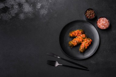 Dolma, stuffed grape leaves with rice and meat on a dark background. Caucasian and Turkish cuisine