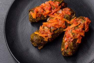 Dolma, stuffed grape leaves with rice and meat on a dark background. Caucasian and Turkish cuisine