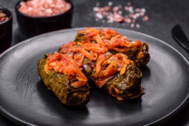 Dolma, stuffed grape leaves with rice and meat on a dark background. Caucasian and Turkish cuisine