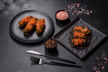 Dolma, stuffed grape leaves with rice and meat on a dark background. Caucasian and Turkish cuisine