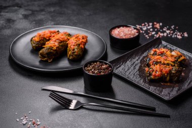 Dolma, stuffed grape leaves with rice and meat on a dark background. Caucasian and Turkish cuisine