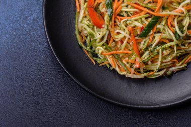 Beton zemin üzerinde ince dilimlenmiş havuç ve kabak salatası. Vejetaryen mutfağı