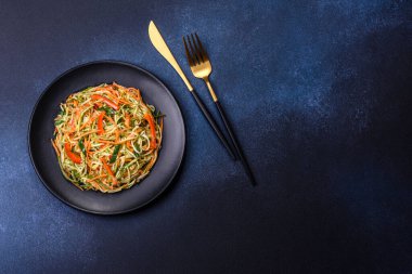 Beton zemin üzerinde ince dilimlenmiş havuç ve kabak salatası. Vejetaryen mutfağı