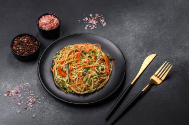 Beton zemin üzerinde ince dilimlenmiş havuç ve kabak salatası. Vejetaryen mutfağı