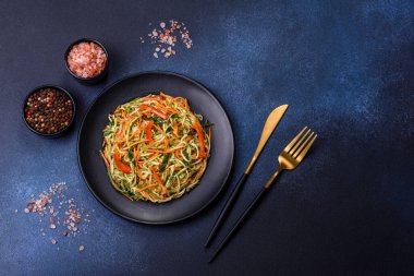 Beton zemin üzerinde ince dilimlenmiş havuç ve kabak salatası. Vejetaryen mutfağı