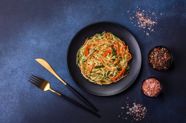 Beton zemin üzerinde ince dilimlenmiş havuç ve kabak salatası. Vejetaryen mutfağı