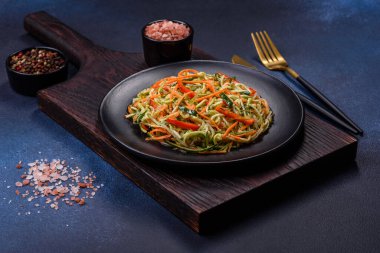 Beton zemin üzerinde ince dilimlenmiş havuç ve kabak salatası. Vejetaryen mutfağı