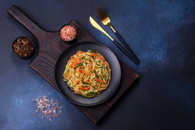 Beton zemin üzerinde ince dilimlenmiş havuç ve kabak salatası. Vejetaryen mutfağı